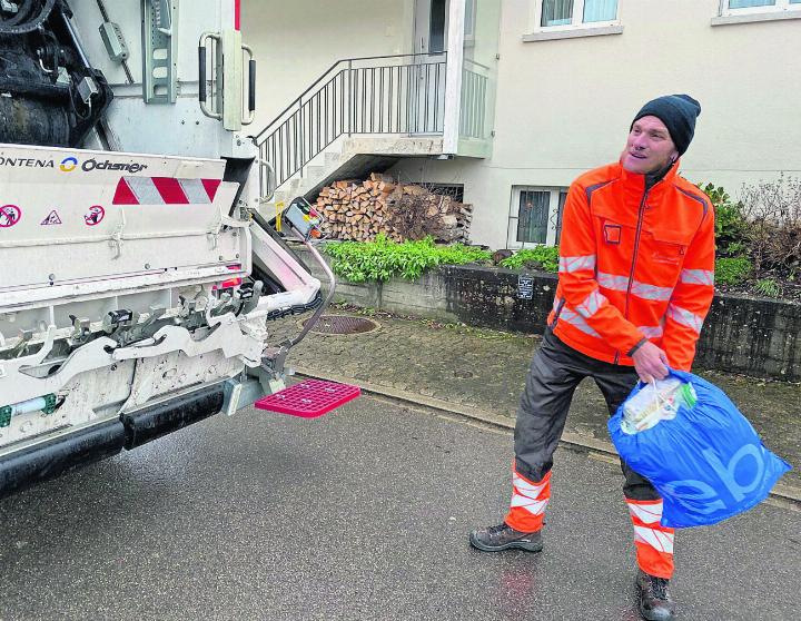 Lader Silvio Andermatt wirft die Säcke mit Schwung in den Kehrichtwagen. Foto: fl