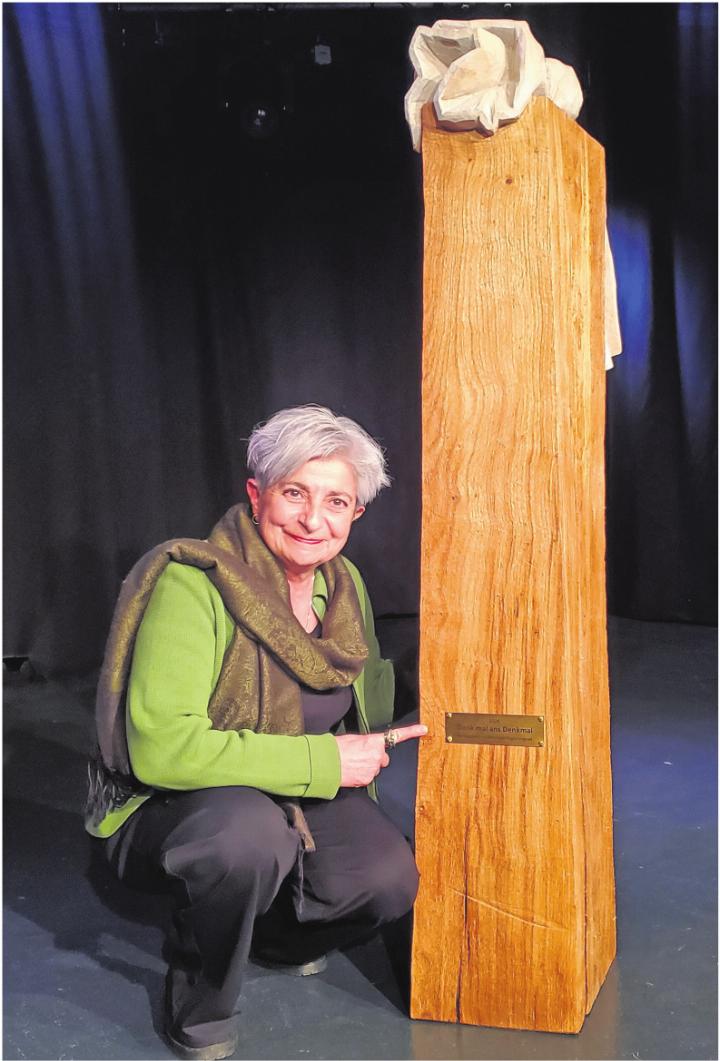 Maria Greco neben der Holzstele von Daniel Züsli. Foto: dg
