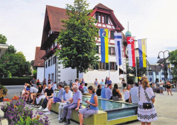 Vor Beginn der Veranstaltung machen es sich die Teilnehmenden auf dem Platz vor dem Rathaus gemütlich und kommen miteinander ins Gespräch. Foto: hi