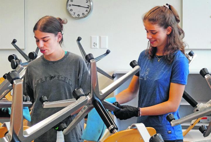 Fadrina (links) und Mareia Küng reinigen die vielen Stühle im Klassenzimmer.