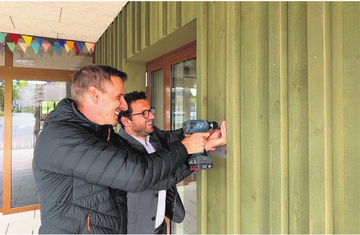 Gemeinsam mit Pascal Ming, Leiter Hochbau, montierte Bauvorstand Zari Dzaferi die neue Zertifizierungstafel. Foto: zVg