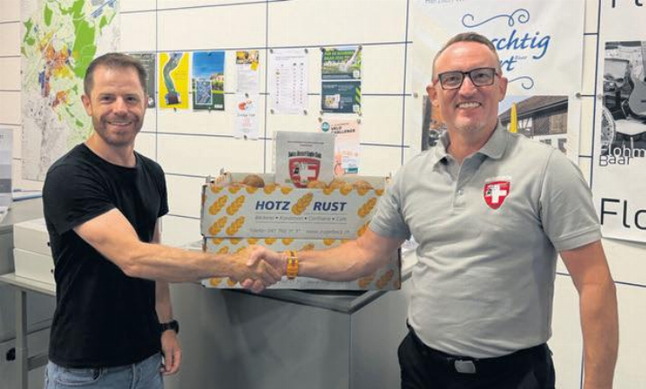 Marco Späni von der Gemeinde Baar und Marcel Elsener, Präsident des Swiss Desert Eagle Club, bei der Übergabe der Gipfeli im Gemeindegebäude. Foto: zVg